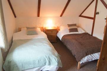 The cosy twin bedroom has sloping ceilings.