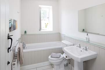 The bright family bathroom has a bath with shower attachment and a shower cubicle.
