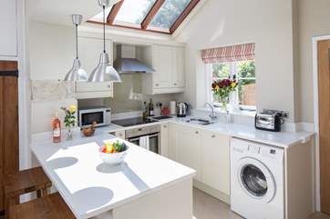 The very well-equipped kitchen has an induction hob, compact dishwasher and washing machine.