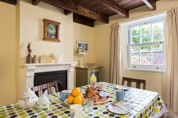 This pretty dining-room in this character cottage has a feature fireplace.