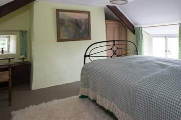 Bedroom 1, accessed via three steps from the staircase, has a cast iron double bed.