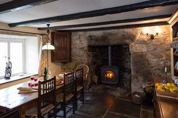 The wood-burner sits in an ancient inglenook fireplace in the dining-room.