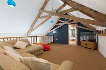 There is a mezzanine sitting-room where you can curl up to watch films. The door leads through to the magnificent double bedroom. The first floor beams are a great feature but are low where they meet.