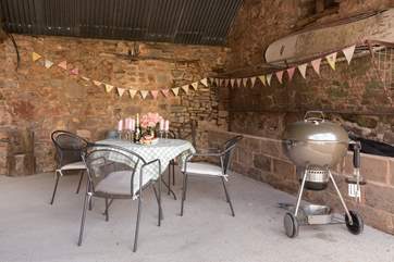 At the front of The Long Barn, alongside the covered parking for guests, is this cheerful open fronted outside eating and barbecue-area.
