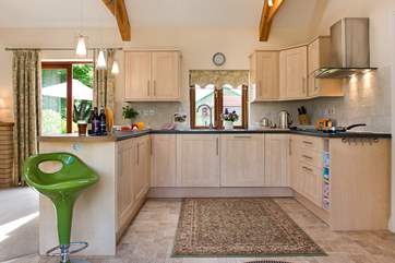 The stylish kitchen sits at one end of the open plan living-room.