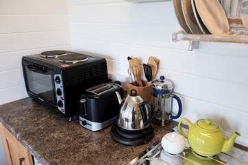 The kitchen area is well-equipped, including an electric cooker (mini oven and two-ring hob) and microwave.