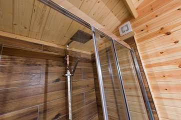 With a big shower cubicle and drench head shower.
