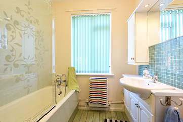 The bathroom with a bath and fitted shower.