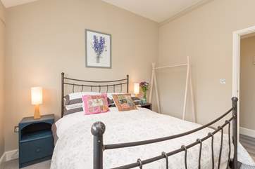 The iron-framed bed adds old-style character and works well with the very modern clothes stand.