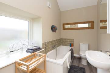 Next to the second bedroom, down a step, is this family bathroom with bath and hand held shower.