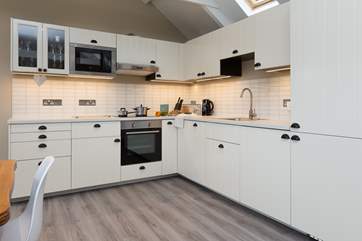 The kitchen offers plenty of work surface space yet does not impact on the feeling of space in the room.