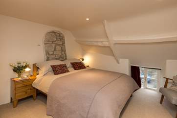 This is the lovely double bedroom on the first floor. The sloping ceilings and low cottage window add to the atmosphere.