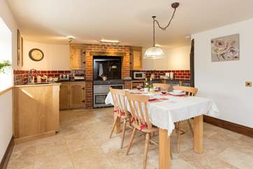 There is a really well-equipped kitchen and a large farmhouse table in this gorgeous open plan living space.