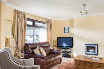 Comfortable chairs and sofas around the TV and wall-mounted electric fire.
