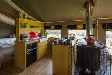 A fully fitted gorgeous kitchen-area with wood-fired range, two ring gas hob and fridge/freezer for your glamping holiday luxuries.
