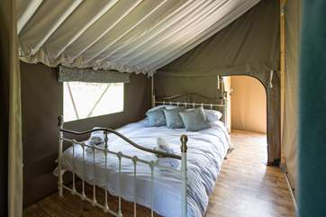 The super-comfy double bed awaits you after a day of being on holiday, the shower room and cloak room are through the door at the back of the tent.