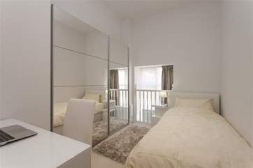 The single bedroom has a quirky window and balustrade.