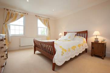 The light-filled master bedroom is charming.
