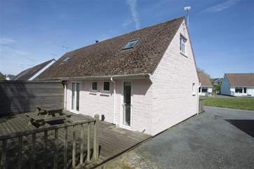 The rear of the property showing the decked area and green in front of the property.