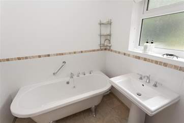 Bathroom with bath tub and views out to the garden.