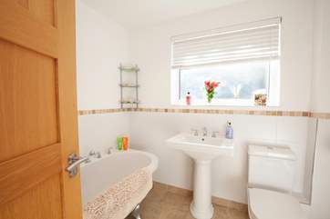 A bright family bathroom on the lower ground floor features a claw-foot bath.