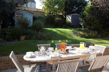 Doors from the lower ground floor sitting room lead to a large patio and garden.