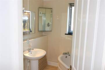 The en suite bathroom with corner bath and shower overhead.