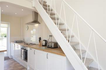 The bright and airy kitchen leads to the backdoor and attached deck.