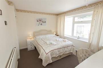 The main bedroom on the second floor overlooks the patio at the front of the property and has a flat screen TV