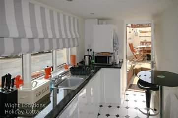 The galley kitchen leads through to the dining-area, inside or out for those lazy summer days.