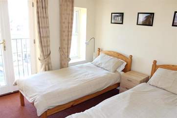 Twin bedroom with doors that open to let in soft seaside breezes.