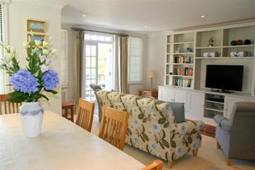 The open plan living room and dining-room has plenty of space and doors that open out onto a terrace that overlooks the pool