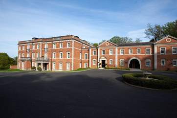 There is a large parking area with allocated bays along one side of this impressive building.