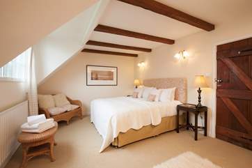 The beautiful master bedroom beautifully complete with wooden beams on the ceiling for that country cottage feel