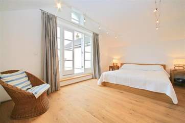 The master bedroom is in the modern extension of Creekside with doors out to a decked terrace