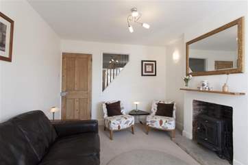 The cosy living room with quirky window to the stairs.