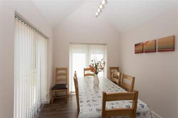 Dining area for up to 8 people and doors to patio