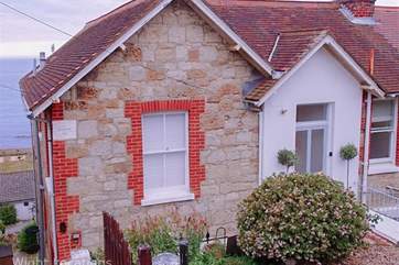 The front entrance has a slight slope with a couple of steps down from the road