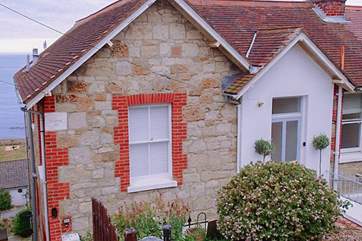 The front entrance has a slight slope with a couple of steps down from the road.