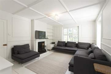 The sitting-room with its modern furnishings and ornamental fireplace is comfortable and inviting.