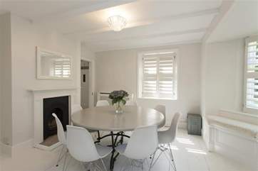 The dining-room with seating for eight and an ornamental fireplace.