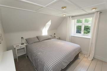 Double bedroom with views out to the leafy garden.