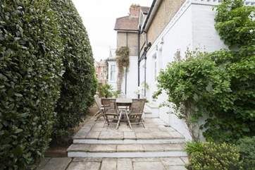 The patio has steps leading to the enclosed garden to the rear