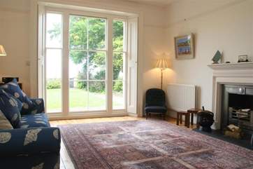 Lovely high ceilinged living room with french doors to the garden