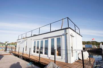 Looking from the pontoon to Vida. With the large glazed doors of the living-area and Bedroom 1 looking out to the front.