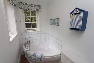 The family bathroom has a spacious corner bath.