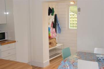 The hallway has a useful area to hang coats and place shoes.