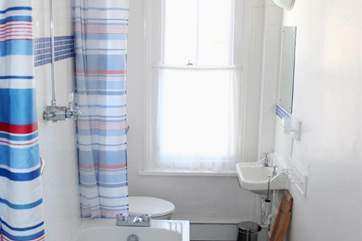 The bright bathroom with an overhead shower.