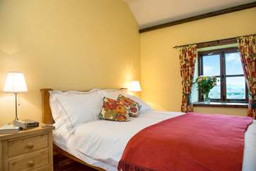 The master bedroom, with stunning views over the breathtaking grounds.