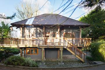 This unique house resembles a giant treehouse but is a sturdy structure comprising wooden rooms built around fir poles.